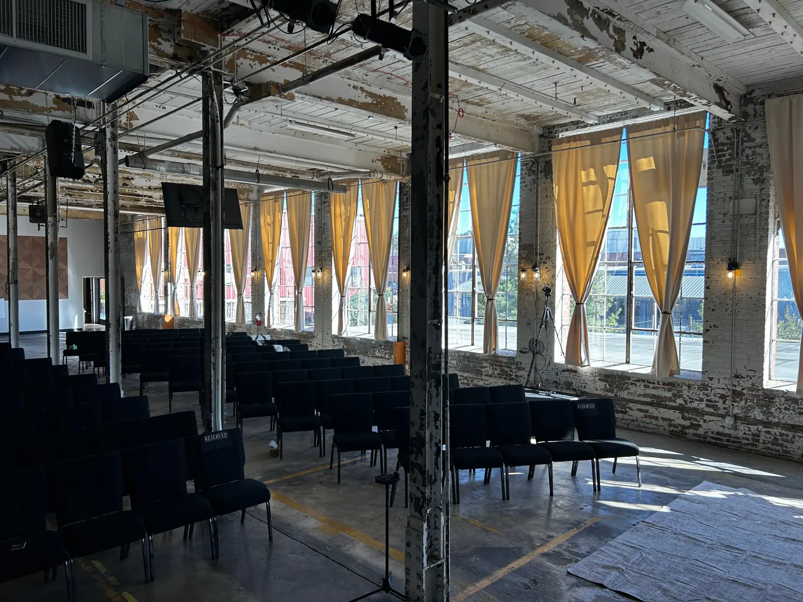The Loom with gold-curtained windows along the brick wall