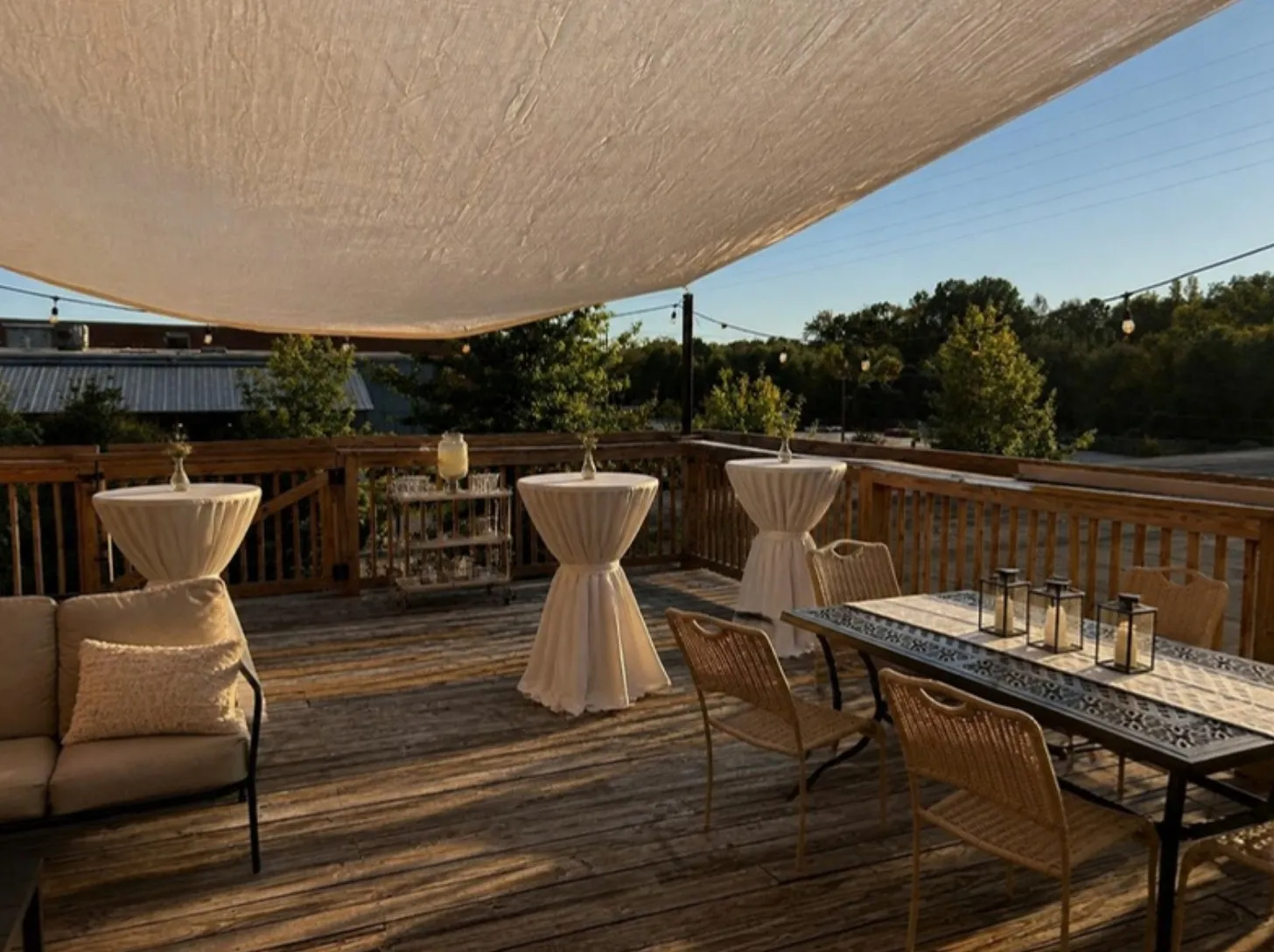 The deck set for an afternoon cocktail hour with linen high-tops